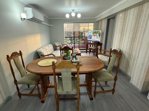 a dining room with a wooden table and chairs at Departamento Plaza Río Bueno in Río Bueno