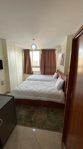 a bedroom with a large bed and a window at ALADDIN PYRAMIDS View in Cairo