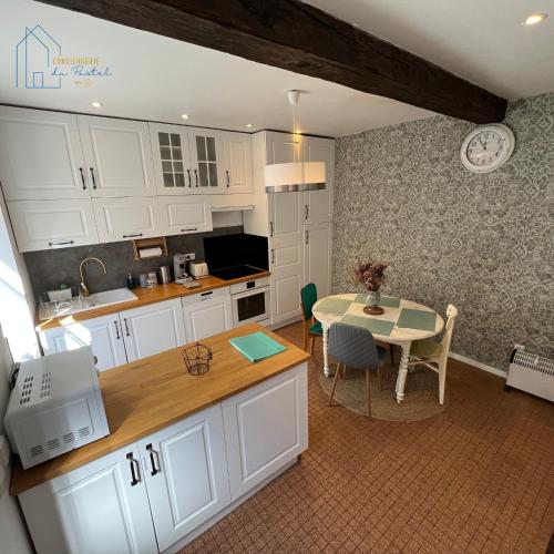 une cuisine avec des armoires blanches et une table et une salle à manger dans l'établissement Maison cosy au centre-ville, à Gaillac