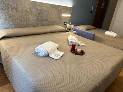 a hotel room with two beds with towels and a red candle at Hotel Santamaria in Villa Santa Maria