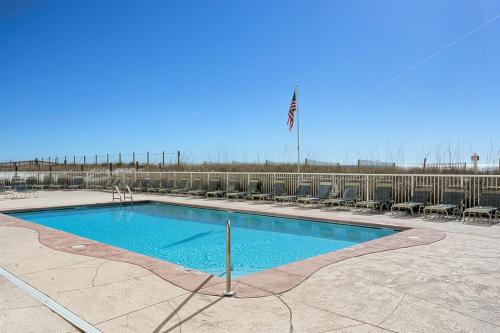 a swimming pool with chairs and a flag at Edgewater West 45 in Gulf Shores