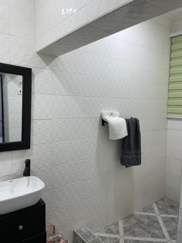 a white bathroom with a sink and a mirror at Da palm Inn in Aburi