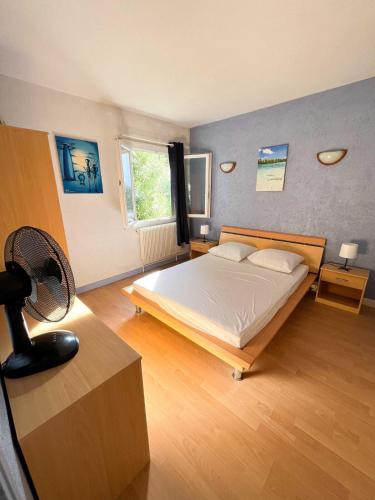 - une chambre avec un lit et un ventilateur dans l'établissement Maison Bord de Mer 6 à 7 pers au Grau du Roi, au Grau-du-Roi