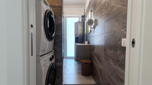 ein Badezimmer mit Waschmaschine und Trockner und ein Flur in der Unterkunft Rossana Apartment in Pescara