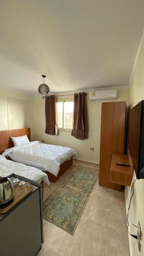 a hotel room with two beds and a television at ALADDIN PYRAMIDS View in Cairo
