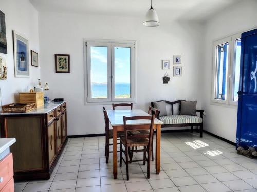 a kitchen with a table and chairs and a couch at Cycladic Horizon Island Villa By Hostandros in Batsi