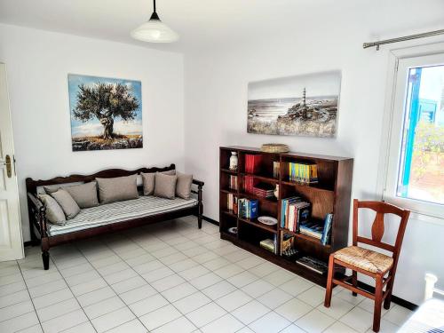 a living room with a couch and a book shelf at Cycladic Horizon Island Villa By Hostandros in Batsi