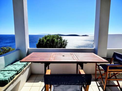 a table on a balcony with a view of the ocean at Cycladic Horizon Island Villa By Hostandros in Batsi