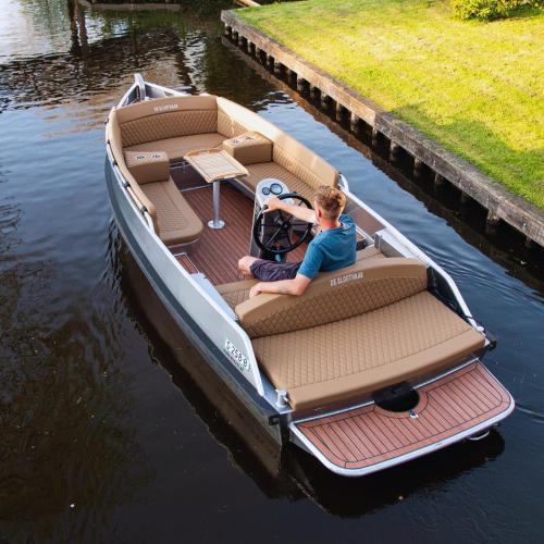 a man sitting in a small boat on the water at De Sloothaak in Giethoorn