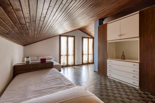 a bedroom with a large bed with a wooden ceiling at Alloggio vista mare in San Bartolomeo al Mare