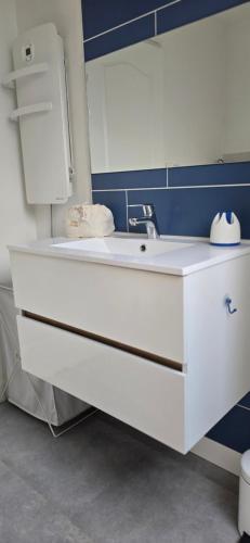 a bathroom with a white sink and a blue wall at La Re Source Chambre et table d'hôtes in Villers-le-Lac