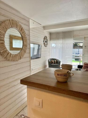 une cuisine avec un comptoir avec un miroir et une table dans l'établissement Studio Plein sud -Histoire de clés, à Agde