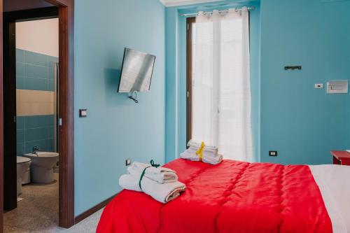 a bedroom with a red bed with towels on it at B&B Dimora Portanuova in Casalbordino