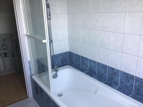 La salle de bains est pourvue d'une baignoire et d'une douche en verre. dans l'établissement Maison calme, vue sur mer, à Saint-Pabu