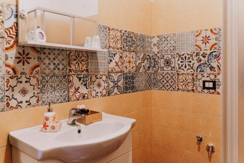 a bathroom with a sink and tiles on the wall at B&B Dimora Portanuova in Casalbordino