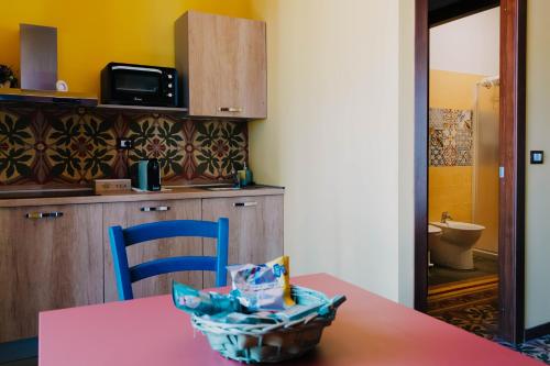 a kitchen with a pink table and a blue chair at B&B Dimora Portanuova in Casalbordino