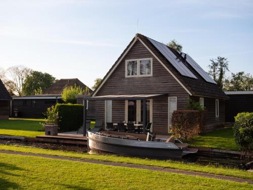 a boat parked in front of a house at De Sloothaak in Giethoorn