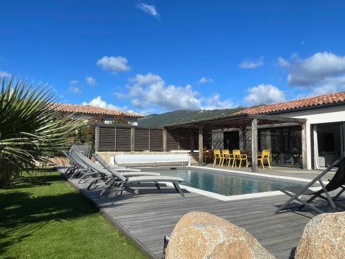 une arrière-cour avec une piscine, des chaises et une maison dans l'établissement Villa Plein pied 8 pers piscine chauffée privée proche plage San Cipriano Cala Rossa Climatisation WIFI, à Lecci