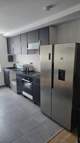 une cuisine avec un réfrigérateur et des armoires en acier inoxydable dans l'établissement Maison, à Oucques