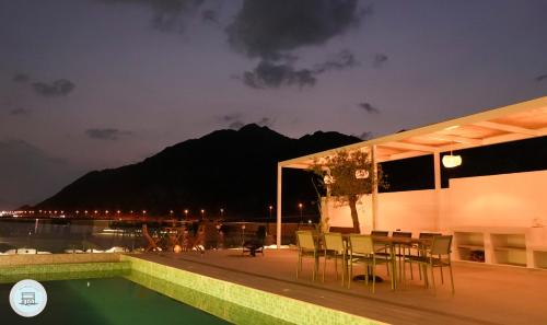 a patio with a table and chairs next to a pool at Al Dana, Sea Breeze Villa, Fujairah in Fujairah