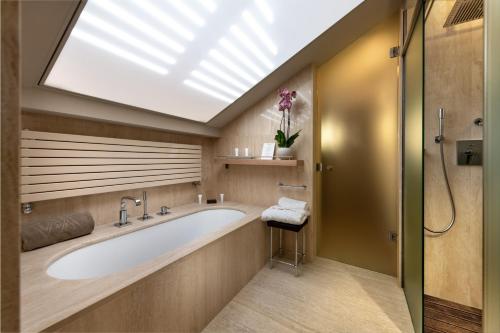 a bathroom with a large tub and a skylight at Relais Villa D'Amelia in Benevello