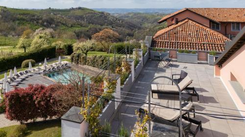 an outdoor patio with a pool and a house at Relais Villa D'Amelia in Benevello