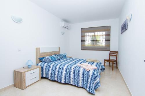 a white bedroom with a bed and a chair at Akivillas Albufeira Aqua V in Albufeira