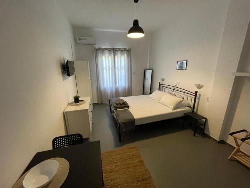 a small bedroom with a bed and a window at Spanos Studios - Panteli in Panteli