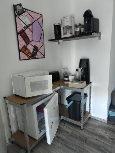a computer desk with a microwave on top of it at Apart Bellagast in Hilchenbach