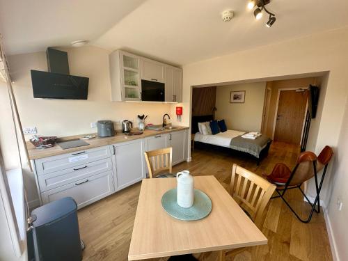 a kitchen with a table and a room with a bed at The Hebridean - Rooms & Apartments in Broadford