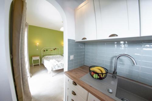 a kitchen with a sink and a room with a bed at Taxi Driver Apartments in Paleokastritsa