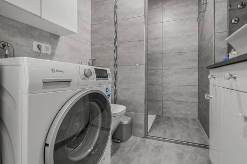 a washing machine in a bathroom with a toilet at Puerto Cruz Relaxing Shared Pool in Puerto de la Cruz