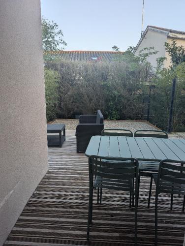 un patio avec une table, des chaises et un canapé dans l'établissement Le petit cocon de Montrond, à Montrond-les-Bains