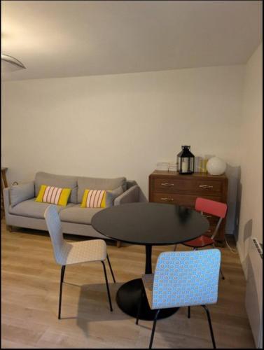 un salon avec un canapé, une table et des chaises dans l'établissement La Datcha d Elvira - Maison de campagne au vert, à Levroux