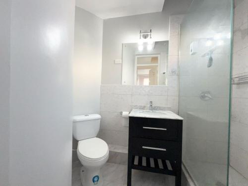 een badkamer met een toilet, een wastafel en een douche bij Seacastle Beach Penthouse in Montego Bay