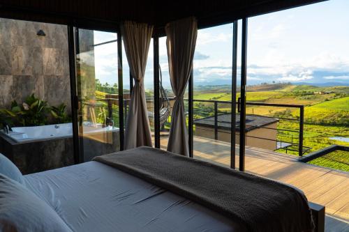a bedroom with a bed and a balcony with a view at Oasis Barichara in Barichara