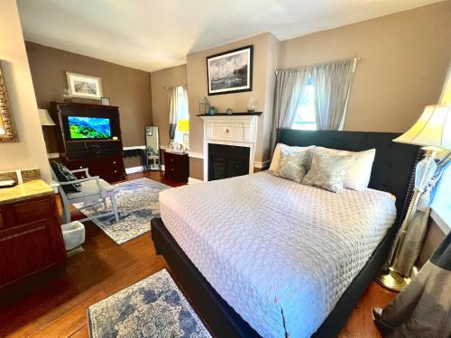 a bedroom with a bed and a living room with a tv at Old Brick Inn in Saint Michaels