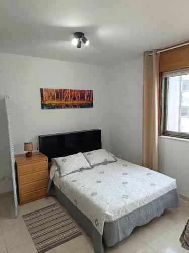 a bedroom with a bed and a painting on the wall at Estudio Centro A Guarda in A Guarda
