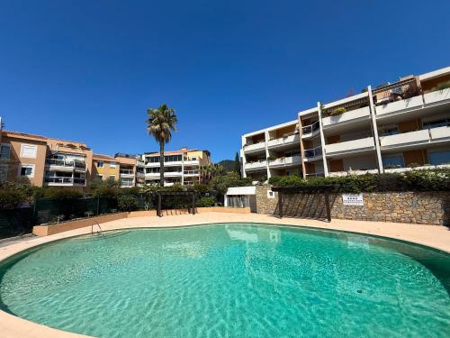 une grande piscine en face d'un immeuble dans l'établissement Duplex - Piscine - Vue mer 180 degrès, à Carqueiranne