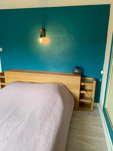 une chambre avec un lit et un mur bleu dans l'établissement Les Meublés de la Corniche, à Argelès-sur-Mer