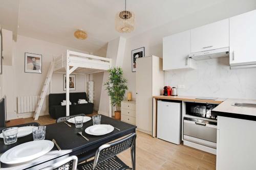 une cuisine et un salon avec une table et des chaises dans l'établissement Cozy apartment with garden near République, à Paris