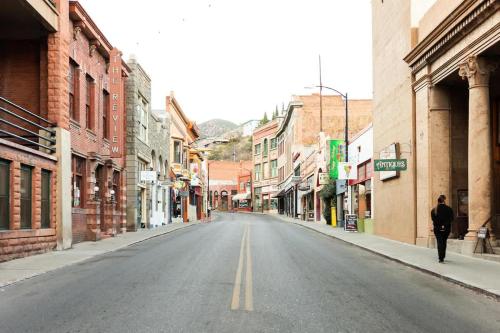 a man walking down an empty street in an old town at The Signature King with Mountain Views in Bisbee