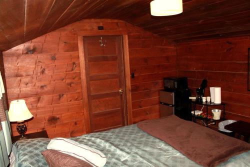 a bedroom with a bed and a wooden wall at Family Cabin Rental on Beautiful Ranch near Yellowstone National Park, Wyoming in Wapiti