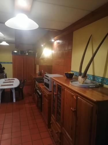 a kitchen with wooden cabinets and a table in it at Valleycenter guestlodge in Johannesburg