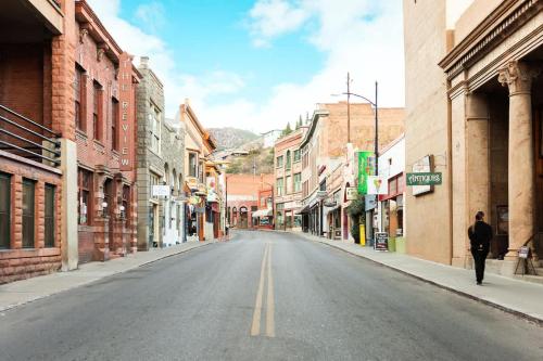 an empty city street with a person walking down the street at The Signature Queen with Mountain Views in Bisbee
