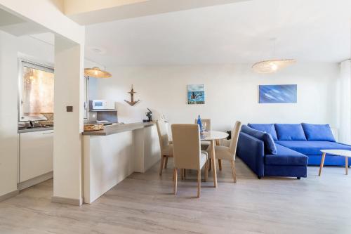 un salon avec un canapé bleu et une table dans l'établissement L'Ancrage - Sea view terrace - Beach 50m away, à Saint-Malo