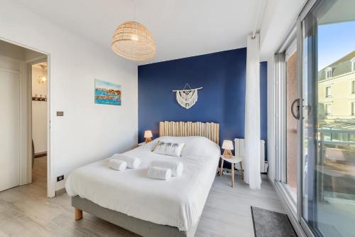 - une chambre avec un lit blanc et un mur bleu dans l'établissement L'Ancrage - Sea view terrace - Beach 50m away, à Saint-Malo