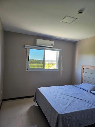 a bedroom with a bed and a window at Departamento Premium in Encarnación