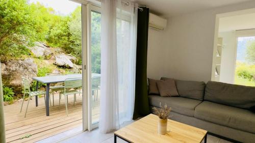 - un salon avec un canapé et une table sur une terrasse dans l'établissement CASA CUCCHI, à Porto-Vecchio