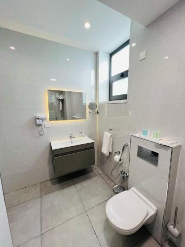 a bathroom with a toilet and a sink and a mirror at فندق الأمراء بلازا in Ma‘ān